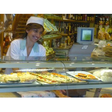 Elisabetta al banco del pane, pizza e dolci durante il giorno di inaugurazione della bottega